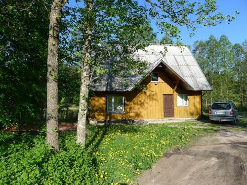 ein Haus mit einem davor geparkt in der Unterkunft Brīvdienu māja Lejas in Pope