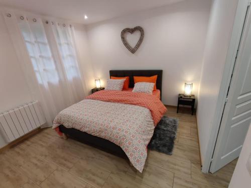 1 dormitorio con 1 cama con almohadas de color naranja y pared cardiaca en Vitospa, en Cauffry