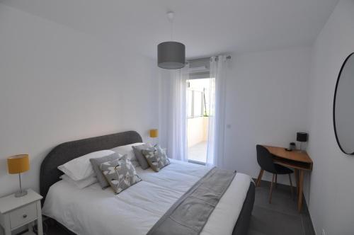 - une chambre avec un lit blanc, un bureau et une fenêtre dans l'établissement Fantastic Two-bedroom Apartment - Le Jardin des Iles, à Antibes