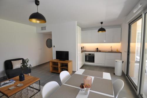 une cuisine et un salon avec une table et des chaises dans l'établissement Fantastic Two-bedroom Apartment - Le Jardin des Iles, à Antibes