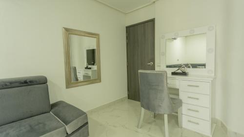 カルタヘナ・デ・インディアスにあるAPARTAMENTO MARINARE DE 2 HABITACIONES CON SALIDA DIRECTA A LA PLAYAのベッドルーム(椅子、ドレッサー、鏡付)