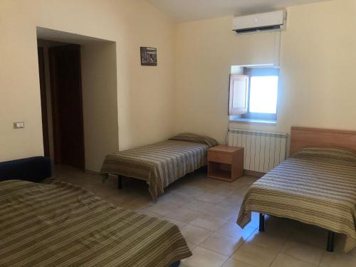 a room with two beds and a window at Hostels Euro Mediterraneo in Rossano