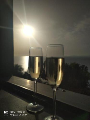 two glasses of white wine sitting on a window sill at Marechiaro Home Holiday in Vico Equense