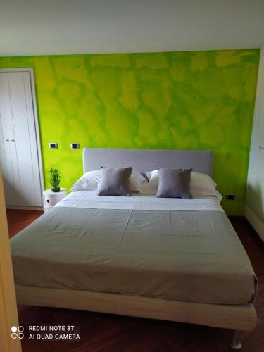 een slaapkamer met een groot bed met een groene muur bij Marechiaro Home Holiday in Vico Equense