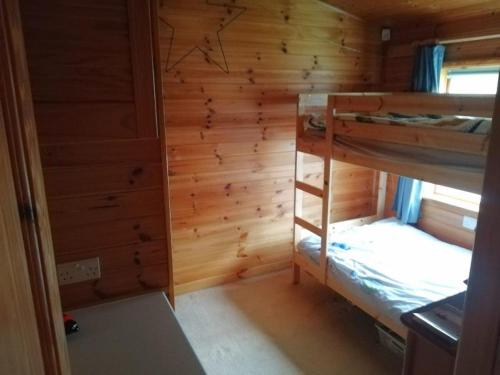 a room with two bunk beds in a cabin at Wooden Forest Lodge by the sea in Milford on Sea