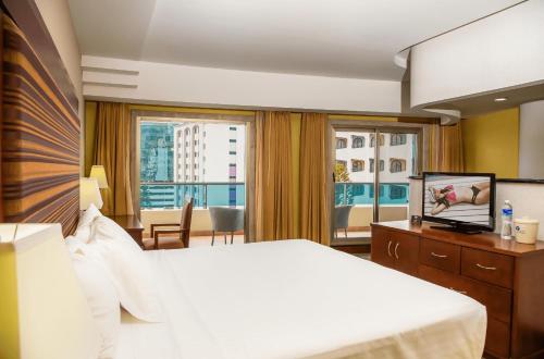 テグシガルパにあるHotel Plaza Juan Carlosのベッドと大きな窓が備わるホテルルームです。