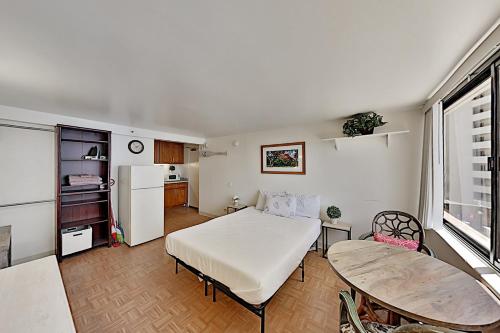 een slaapkamer met een bed en een tafel en een keuken bij Hawaiian Monarch 801 condo in Honolulu