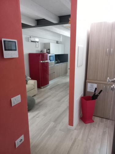 an open room with a kitchen and a red wall at La casa di Virginia in Arco