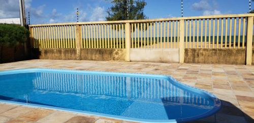 una piscina azul frente a una valla en Casa Darci - Beira-mar, no Condomínio Village, en Maragogi