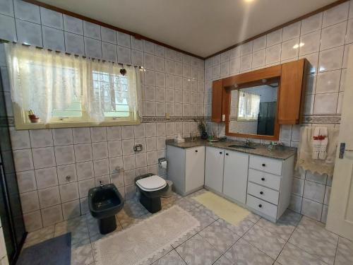 a bathroom with a toilet and a sink and a mirror at Sítio Dos Amigos in Canela