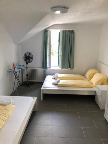 a bedroom with two beds and a window at Villa Matten in Matten