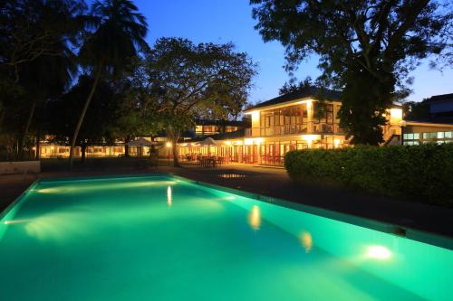 a swimming pool in front of a building at night at The Lakeside at Nuwarawewa in Anuradhapura