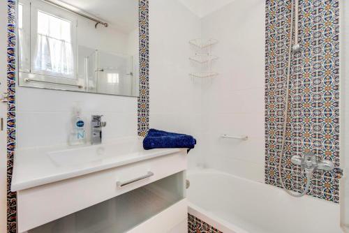 a white bathroom with a sink and a shower at Captivating 1-Bed House in Arona in Arona