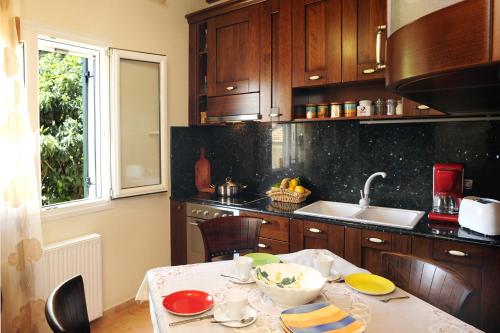 a kitchen with wooden cabinets and a table with food on it at Villa Edem in Kassiopi