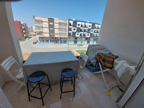 een tafel en stoelen op een balkon met uitzicht op een gebouw bij Logement Sable et Vagues in Saidia 