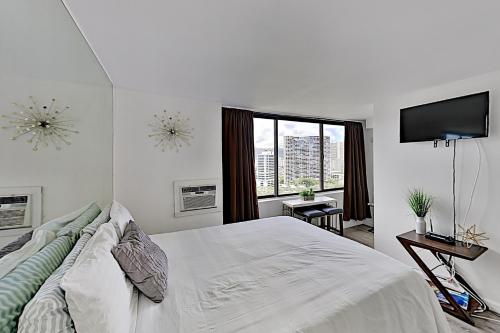 um quarto branco com uma cama grande e uma janela em Hawaiian Monarch 2312 condo em Honolulu