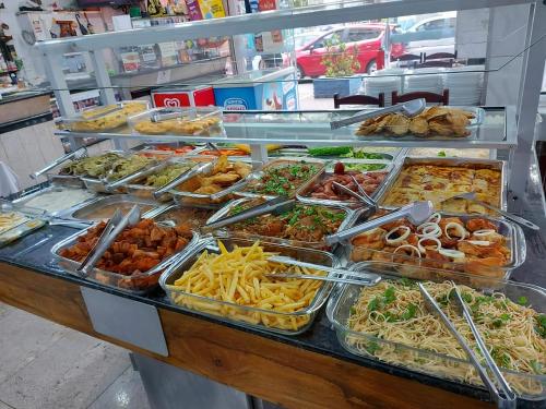 a buffet filled with different types of food in trays at Hotel Joia Fina in Aparecida