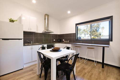 a kitchen with a white table and chairs and a window at Gardenview in Wangaratta