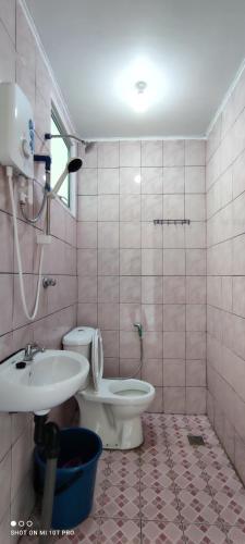 a bathroom with a toilet and a sink at Nulu View Cabin in Kundasang