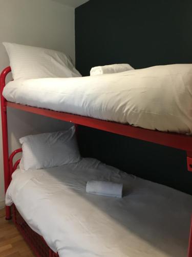 two bunk beds with white sheets and a pillow at Cheap Budget Accommodation in Galway