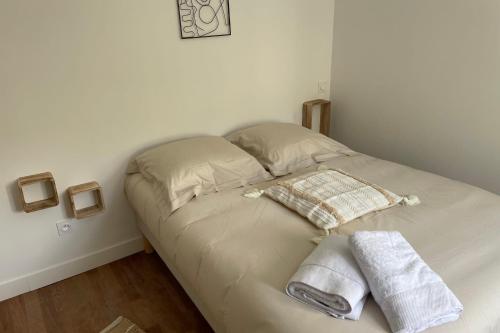 - un lit avec 2 serviettes dans une chambre dans l'établissement Le Poulorio 5 - Proche Gare By Locly, à Lorient