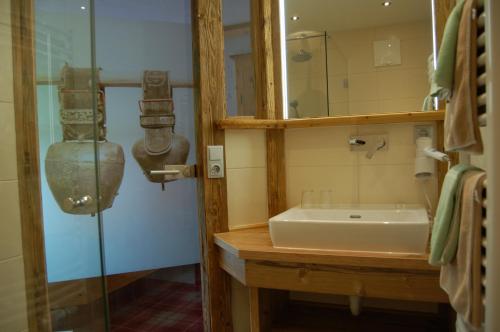 łazienka z umywalką i przeszkloną kabiną prysznicową w obiekcie Hotel Schweizerhof w mieście Oberau