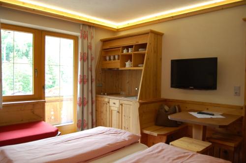 a bedroom with a bed and a television and a desk at Hotel Schweizerhof in Oberau