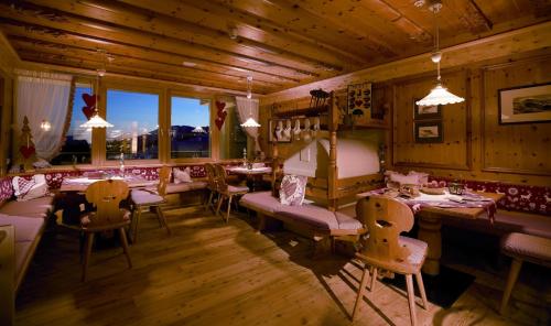 ein Restaurant mit Tischen und Stühlen in einem Raum in der Unterkunft Hotel Bacherhof in Meransen