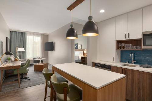 eine Küche mit einer Theke und Stühlen in einem Zimmer in der Unterkunft Staybridge Suites Rochester - Mayo Clinic Area, an IHG Hotel in Rochester