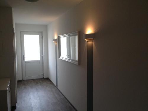 a hallway with a window and a light on the wall at Aparthotel am Heidensee in Schwerin