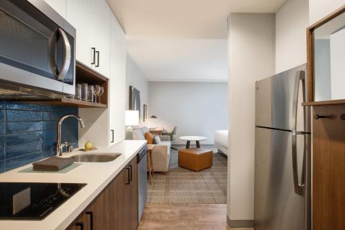 a kitchen with a sink and a refrigerator at Staybridge Suites Rochester - Mayo Clinic Area by IHG in Rochester