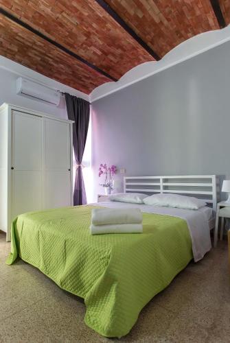 a bedroom with a large bed with a green blanket at Miss Sicily B&B in Terrasini