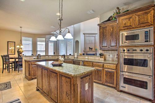 a large kitchen with wooden cabinets and stainless steel appliances at 4 Mi to Grapevine Lake Texas Home with Media Room in Flower Mound