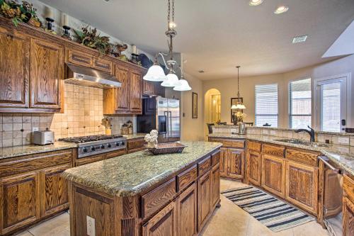 a large kitchen with wooden cabinets and granite counter tops at 4 Mi to Grapevine Lake Texas Home with Media Room in Flower Mound