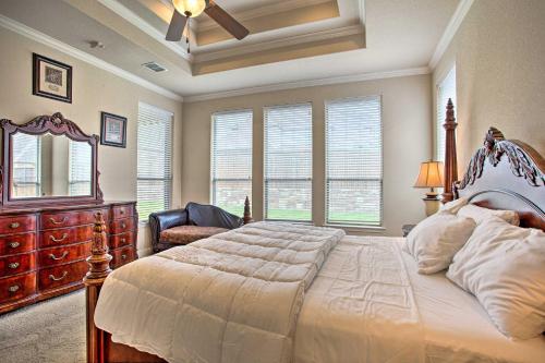 a bedroom with a large bed with a dresser and windows at 4 Mi to Grapevine Lake Texas Home with Media Room in Flower Mound