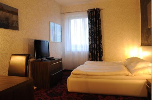 a hotel room with a bed and a television at Hotel Amerika in Havířov