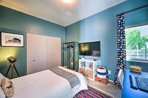 a bedroom with blue walls and a bed and a television at Seattle Retreat with Canal and Mountain Rooftop Views! in Seattle