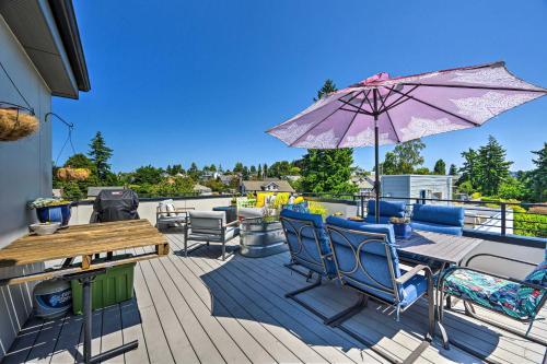 a patio with a table and chairs and an umbrella at Seattle Retreat with Canal and Mountain Rooftop Views! in Seattle