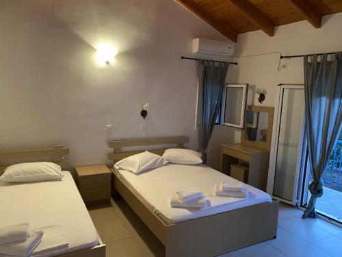 a bedroom with two beds and a window at VILLA NOULI in Sarakiniko