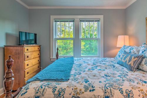 a bedroom with a bed and a dresser and windows at Restored Mars Hill Home on 1 Acre Walk to Town! in Mars Hill