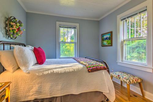 a bedroom with a bed and two windows at Restored Mars Hill Home on 1 Acre Walk to Town! in Mars Hill