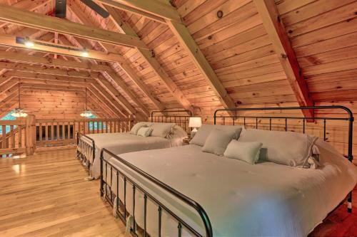 a bedroom with two beds in a room with wooden ceilings at 7 Mi to Ski Slopes Mars Hill Cabin with Hot Tub! in Mars Hill