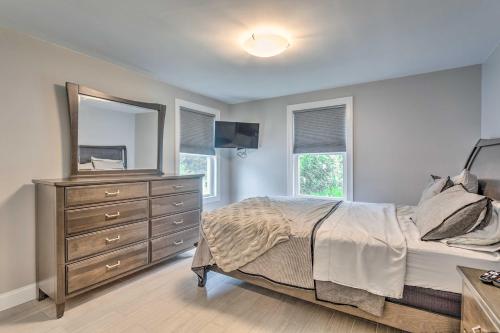 a bedroom with a bed and a dresser and a mirror at Narragansett Escape by Narrow River and Beaches in Narragansett