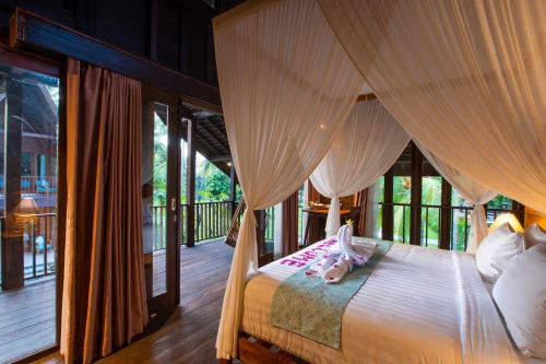 a bedroom with a canopy bed in a house at The Kirana Tembok in Tejakula