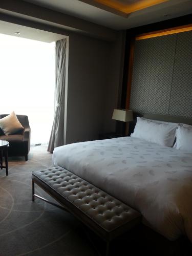 a bedroom with a large bed and a window at Primus Hotel Qipan Moutain Shenyang in Shenyang