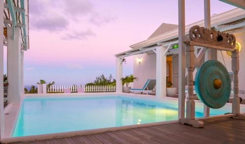 a swimming pool with a gazebo next to a house at Au Temps D'antan- Ile Rodrigues in Rodrigues Island