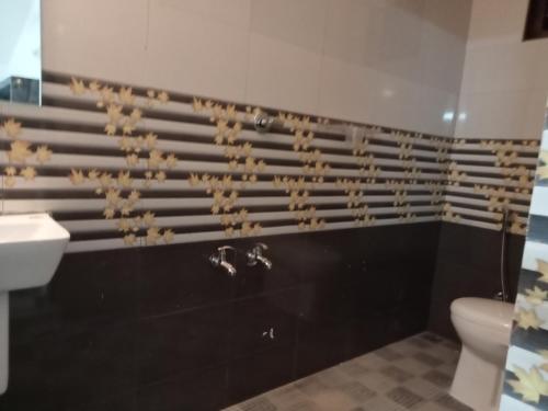 a bathroom with a toilet and a sink at SanSree's Puzhakkal Homestay in Wayanad