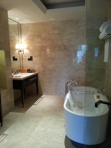 a bathroom with a tub and a sink at Primus Hotel Qipan Moutain Shenyang in Shenyang