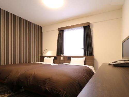 a hotel room with two beds and a window at Odawara Terminal Hotel in Odawara