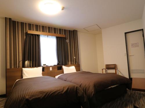 a hotel room with a bed and a window at Odawara Terminal Hotel in Odawara